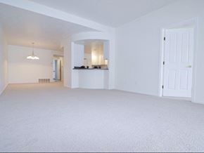 East Lansing apartment for rent - an empty living room with a door to the kitchen