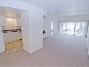 East Lansing apartment for rent - an empty living room with a kitchen and a window