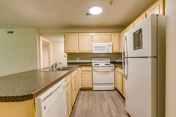 East Lansing apartment for rent - an updated kitchen with white appliances and granite counter tops
