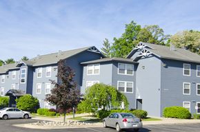 East Lansing apartment for rent - a blue apartment building with cars parked in front of it