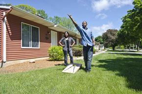 East Lansing triplex for rent - a man and woman standing in front of a house with a kite