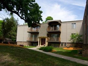 East Lansing apartment for rent - an apartment building with a sidewalk in the grass