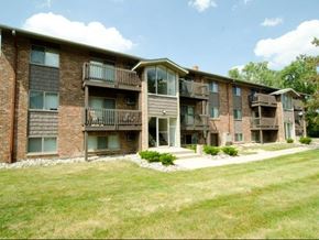 East Lansing apartment for rent - a brick apartment building with balconies and a grass yard