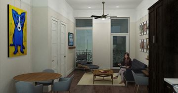 New Orleans apartment for rent - A woman is sitting on a couch in a living room with a ceiling fan and a painting of a dog on the wall.