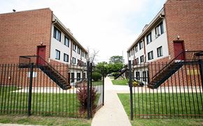 Chicago townhouse for rent - A red brick building with a black gate in front.