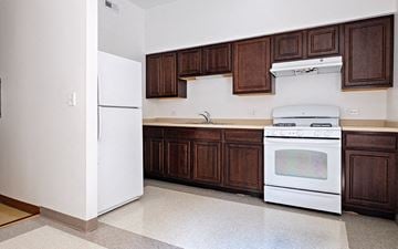 Chicago apartment for rent - A white fridge and oven in a kitchen with brown cabinets.