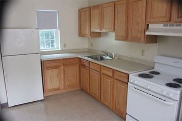 Claremont apartment for rent - A kitchen with wooden cabinets and white appliances.