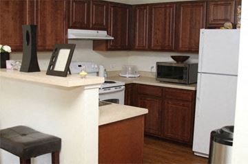 Chicago apartment for rent - A kitchen with brown cabinets and a white refrigerator.
