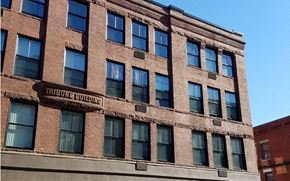 Framingham apartment for rent - a large brick building with windows and a street sign