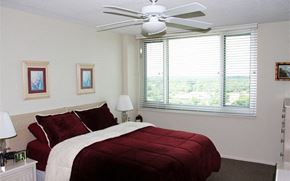 Melbourne apartment for rent - a bedroom with a bed and a ceiling fan and a window