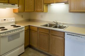 Spirit Lake apartment for rent - A kitchen with a white stove and wooden cabinets.