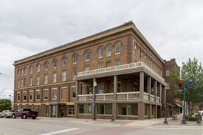Spirit Lake apartment for rent - A large brown building with a balcony on the second floor.