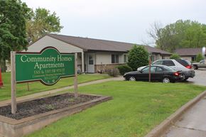 Des Moines triplex for rent - the community homes apartments sign in front of a house