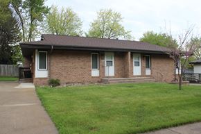 Des Moines triplex for rent - a brick house with a lawn and a sidewalk