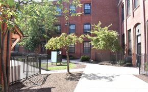 Hartford apartment for rent - the courtyard of a brick building with trees and a sidewalk