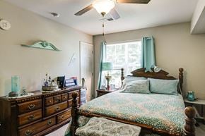 Elizabeth City apartment for rent - a bedroom with a bed and a dresser and a ceiling fan