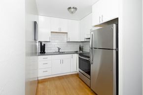 San Francisco apartment for rent - a kitchen with white cabinets and a stainless steel refrigerator