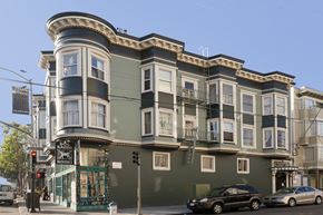 San Francisco apartment for rent - A street view of a green building with a black car parked in front.