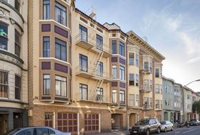 San Francisco apartment for rent - A row of apartment buildings with cars parked in front.
