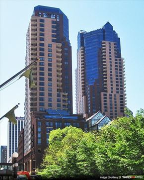 Stpaul apartment for rent - A cityscape with tall buildings and trees in the foreground.