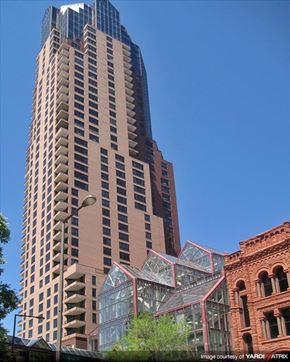 Stpaul apartment for rent - A tall building with a glass facade stands next to a smaller brick building.