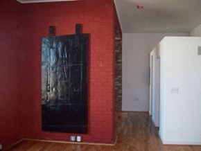 Petersburg apartment for rent - a red brick wall with a black painting on it