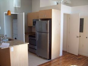 Petersburg apartment for rent - an empty kitchen with a stainless steel refrigerator