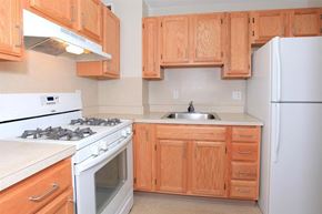 Boston apartment for rent - a kitchen with white appliances and wooden cabinets