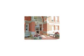 Gloucester apartment for rent - a view of the front of a building with flowers and a bench