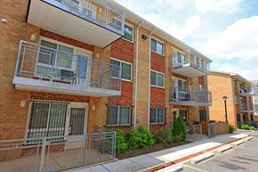 Washington apartment for rent - a brick apartment building with two balconies and a sidewalk