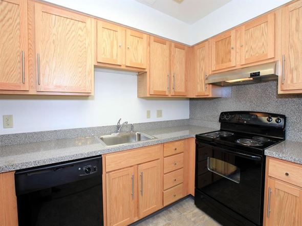 Lexington townhouse for rent - a kitchen with black appliances and wooden cabinets