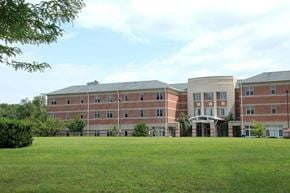 Holliston apartment for rent - a large brick building with a green lawn in front of it