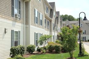 Harrisville apartment for rent - a row of houses with trees and bushes in front of them