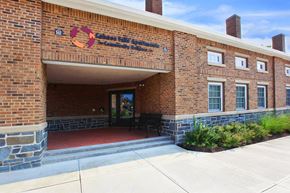 Cohoes apartment for rent - the front of a brick building with a red walkway