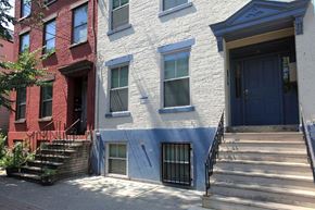 Albany apartment for rent - a white brick house with a blue door and stairs
