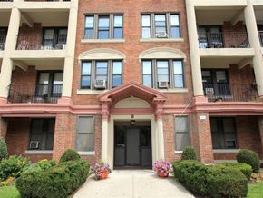 Dorchester apartment for rent - the front of a brick apartment building with potted plants