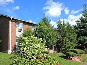 Vernon apartment for rent - a garden in front of a brick apartment building