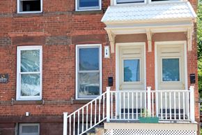 Schenectady apartment for rent - a red brick house with a white porch and a white railing