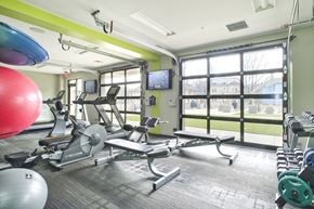 Allston apartment for rent - a gym with weights and cardio equipment and a window