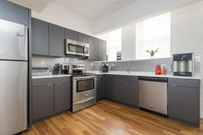 Allston apartment for rent - a kitchen with gray cabinets and stainless steel appliances