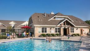 Greenfield apartment for rent - people swimming in a pool in front of a house
