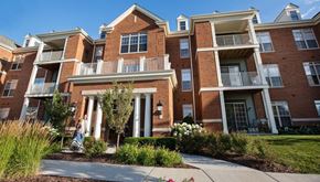 Brookfield apartment for rent - A large brick apartment building with a woman walking in front.