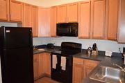 Waretown apartment for rent - a kitchen with black appliances and wooden cabinets