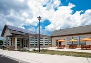 Newark apartment for rent - the front of a building with tables and umbrellas and solar panels