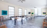 Newark apartment for rent - a dining room with tables and chairs in a room with large windows