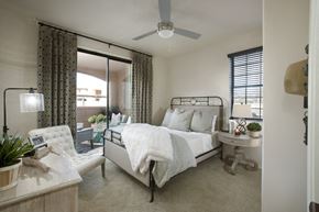 Tucson apartment for rent - a bedroom with a white bed and a ceiling fan