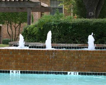 Hurst apartment for rent - A pool with a fountain in the middle of it.