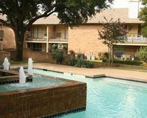 Hurst apartment for rent - A pool with a fountain in the middle of it.
