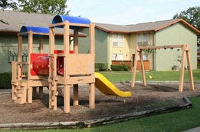 Euless apartment for rent - A wooden playground with a slide and a red and blue slide.