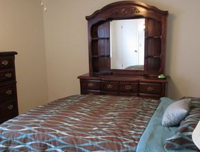 Dover apartment for rent - a bedroom with a bed and a dresser with a mirror